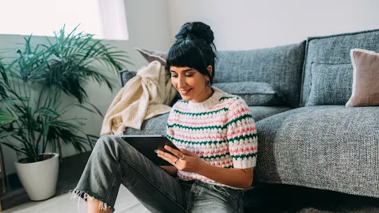 Ein Foto einer Frau, die sich über ihr Tablet Online-Inhalte ansieht
