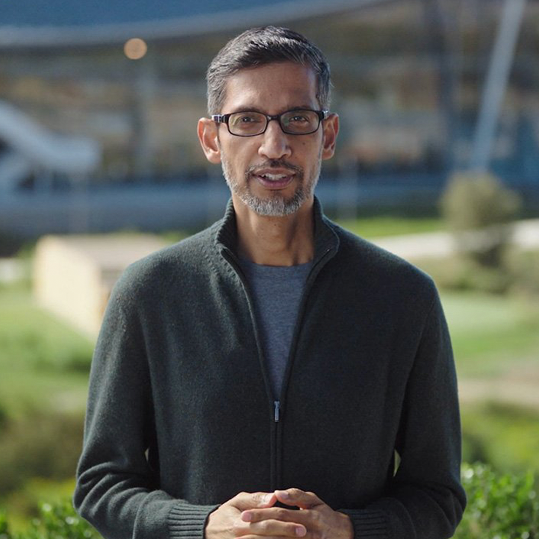 A man wearing glasses standing outside and speaking to the viewer
