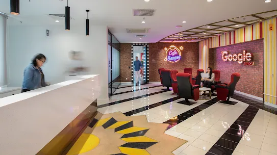 A workspace with brick walls, black-and-white-tiled floors, and red seating.