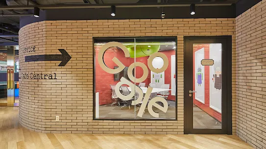 A view of a conference room from the outside. The Google logo is on the glass.