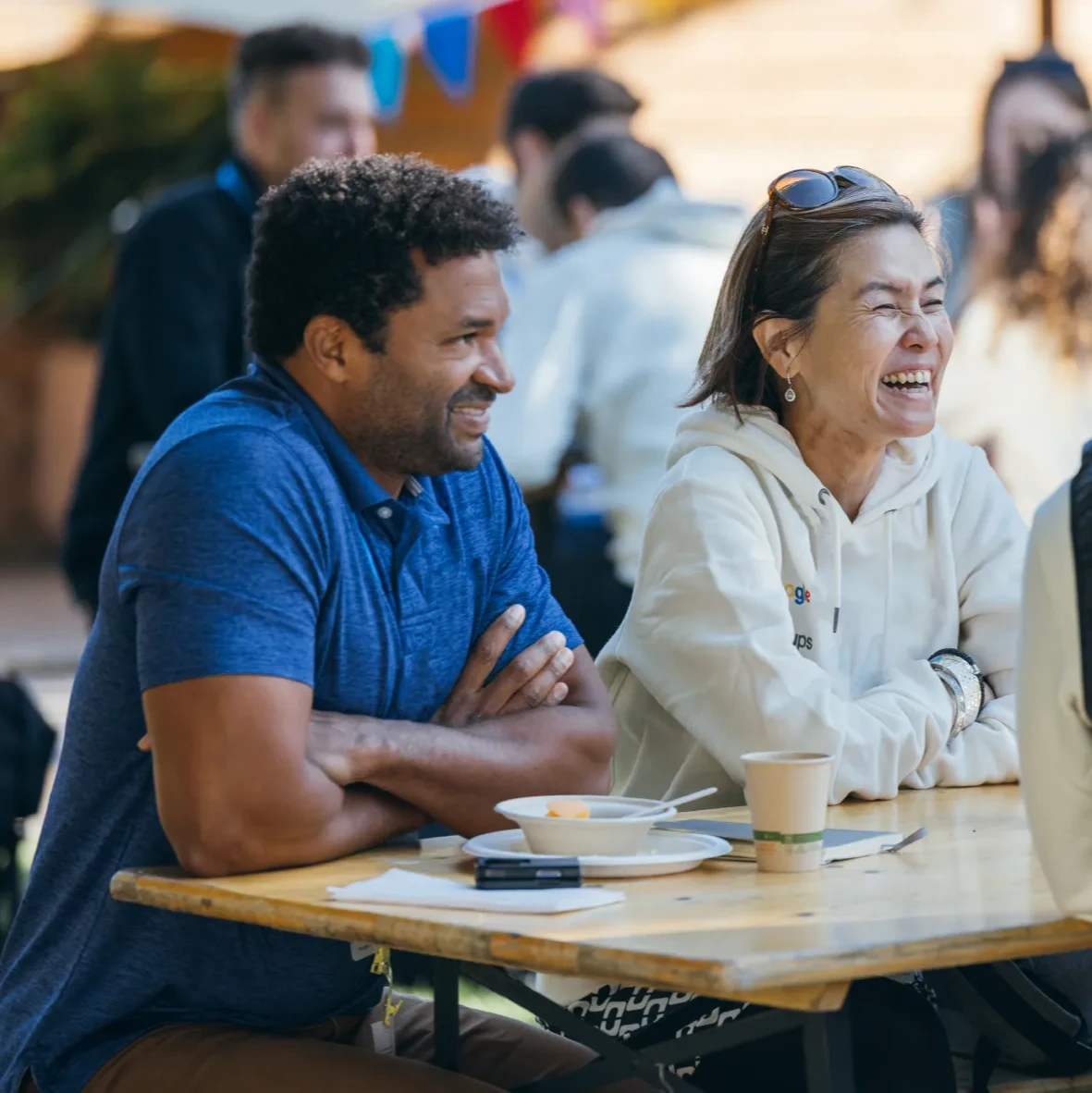 A group of people sitting at a table watching someone speak.