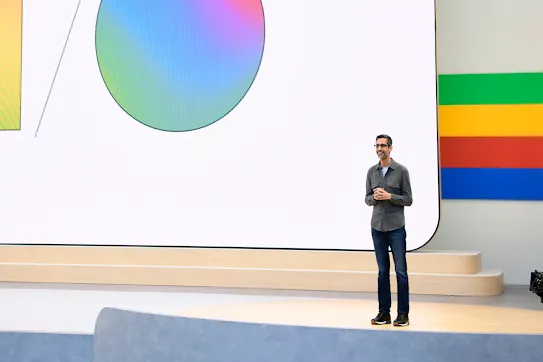 Google and Alphabet CEO Sundar Pichai on stage against a backdrop showing the letters I/O with gradient colors.